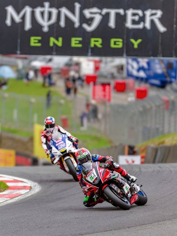 Superbike racing: Glenn Irwin on the Yamaha leads out of a corner beneath the Monster Energy bridge, Brands Hatch 2025